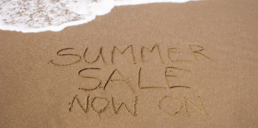 A summer sale written in the sand